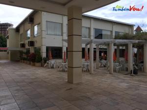 un patio de un hotel con mesas y sillas en diRoma Exclusive Temporada, en Caldas Novas