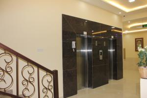 Baño con ducha a ras de suelo junto a una escalera en Sama Sohar Hotel Apartments - سما صحار للشقق الفندقية, en Sohar