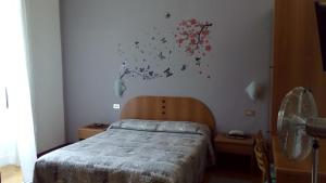 1 dormitorio con 1 cama y una pintura en la pared en Hotel Tirreno, en Milán