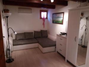 a living room with a couch and a window at Pécsely apartman in Pécsely