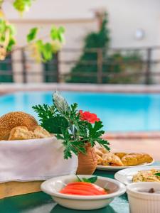 une table avec des assiettes de nourriture et un vase avec des fleurs dans l'établissement Villa Archanes, à Archanes