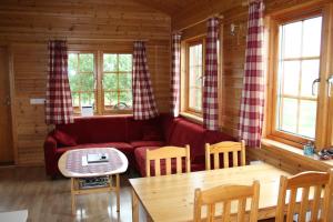 sala de estar con sofá rojo y mesa en Keldudalur Farm Cottages en Keldudalur