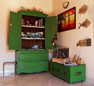 einen grünen Schrank und einen Tisch in einem Zimmer in der Unterkunft Case D'Anna in Castellammare del Golfo