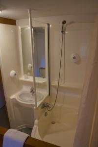 La salle de bains est pourvue d'une douche et d'un lavabo. dans l'établissement Quick Palace Vannes, à Vannes