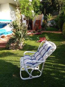 a white bench sitting on the grass in a yard at Villa Marina Big in Laterina +9 photos