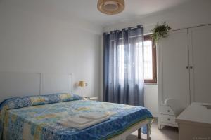 biała sypialnia z łóżkiem i oknem w obiekcie B&B Agata e gli altri w mieście Tortolì