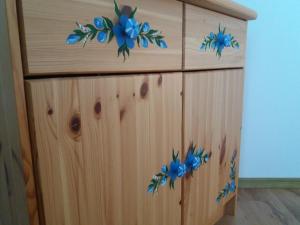 ein Holzschrank mit blauen Blumen darauf in der Unterkunft Bunica Maria - Guesthouse for birders in Mahmudia