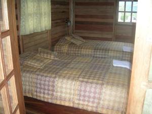 a room with two beds in a cabin at Kopal in Baeza