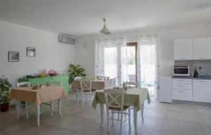 kuchnia i jadalnia ze stołami i krzesłami w obiekcie B&B Agata e gli altri w mieście Tortolì +19 zdjęć