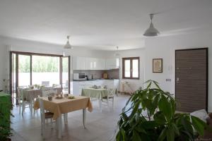 kuchnia i jadalnia ze stołami i krzesłami w obiekcie B&B Agata e gli altri w mieście Tortolì