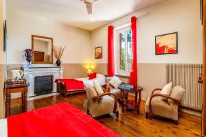 een slaapkamer met een bed met rode gordijnen en een open haard bij Logis Hôtel Restaurant des Corbières in Lagrasse