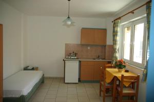 a small kitchen with a bed and a table and a table and chairs at Olympic Star in Hersonissos