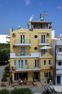 un bâtiment jaune avec des balcons sur son côté dans l'établissement Olympic Star, à Chersónissos