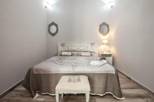 a bedroom with a bed with a table and two mirrors at Le Alcove in Cinisi