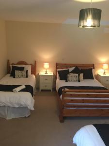 a bedroom with two beds and two lamps on tables at Drumhouse Guesthouse in Knock
