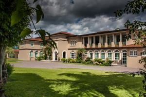 an exterior view of a large building with a yard at Hotel Esmeralda in Atlixco