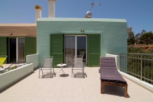 a patio with chairs and a table on a balcony at Athena Villas Olive Grove & Estate in Gouves