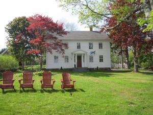 Granville Ferry的住宿－Grand Oak Manor Bed and Breakfast，白色房子前面的一组椅子