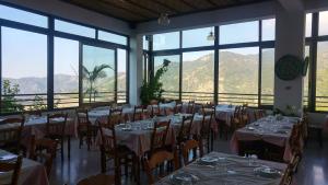 a dining room with tables and chairs and windows at Two Flowers Hotel in Pedoulas