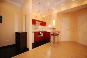a kitchen with red cabinets and a bar stool in it at Wonderful apartment in Chişinău