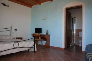 a bedroom with a bed and a desk with a computer at La Tankitta Turismo Rurale in Stintino