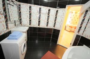 een badkamer met een toilet en een wasmachine bij Wonderful apartment on street Stefan cel mare 132 in Chişinău