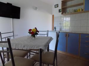 una cocina con una mesa con un jarrón de flores. en Apartment Lopar 15 en Lopar