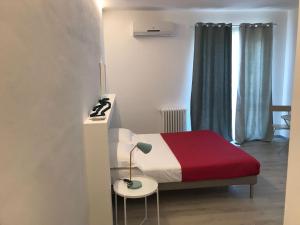 a bedroom with a bed and a table with a lamp at B&B Piazza Marconi in Manfredonia