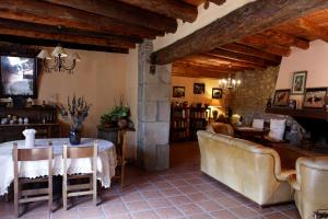 sala de estar con mesa, sillas y TV en Casa Oliban, en Arbaniés