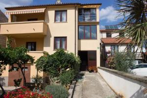 a house in a residential neighbourhood with trees and flowers at Apartment Borik in Pula