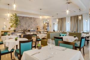 a restaurant with white tables and chairs and a bar at Best Western Plus CHC Florence in Florence