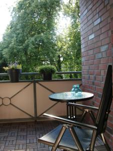 a table and chair on a balcony with a window at Schönes 2-Zi. App. 55 qm - voll möbliert - citynah in Elmshorn