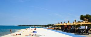 a beach with people laying on the sand and the water at Apartment in Pula/Istrien 17457 in Veli Vrh
