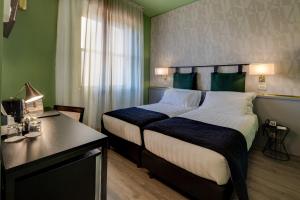 a bedroom with a bed and a desk at Best Western Plus CHC Florence in Florence