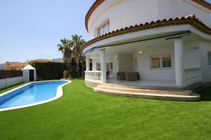 a house with a green lawn and a swimming pool at ARENDA Villa Alamo Pino Alto in Miami Platja