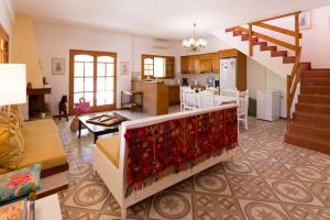 a living room with a staircase and a kitchen at Athena Villas Olive Grove & Estate in Gouves