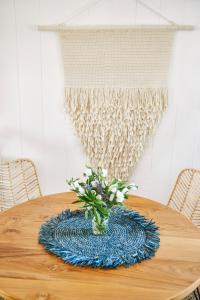 a wooden table with a vase with flowers on it at Hero Beach Club in Montauk