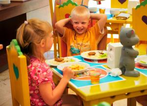a boy and a girl sitting at a table eating food at Martı Myra - Ultra All Inclusive in Tekirova