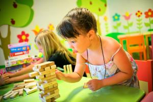 two young girls playing with wooden blocks in a room at Martı Myra - Ultra All Inclusive in Tekirova