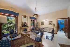 a living room with blue and white chairs and a table at villa il sogno di Cosimo in Ravello