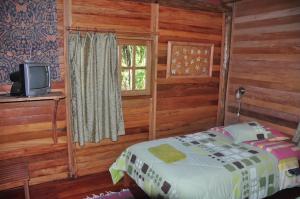 a bedroom with a bed and a tv in a cabin at Kopal in Baeza