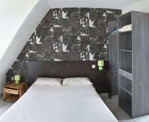 - une chambre avec un grand lit et un mur dans l'établissement Domaine de Kerzuat, à Plouarzel