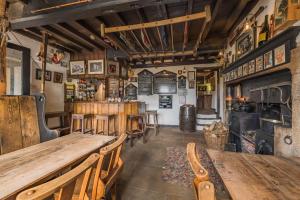 um restaurante com mesas e cadeiras de madeira e uma lareira em Craven Shepherd Huts em Appletreewick