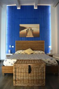 een slaapkamer met een rieten bed en een blauwe muur bij Beatrice Home in Pompei