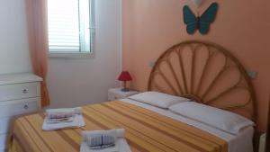 a bedroom with a bed with a butterfly on the wall at Casa vacanze "La Caldosa" in Badesi +57 photos