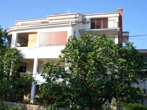 a white building with a tree in front of it at Two-Bedroom Apartment in Crikvenica XXXIII in Dramalj