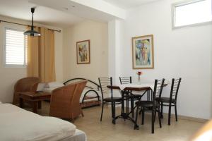 a living room with a dining room table and chairs at Ga'aton Motel in Nahariyya