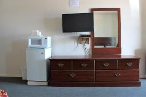 uma cómoda com um micro-ondas e uma televisão por cima em Adobe Inn Motel em Clint