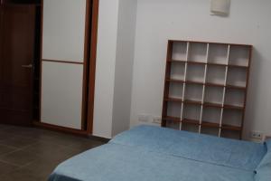 een slaapkamer met een bed en een boekenplank bij Loft Canteras in Las Palmas de Gran Canaria