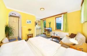 um quarto de hotel com duas camas e um sofá em Pension Karolína em Spindleruv Mlyn